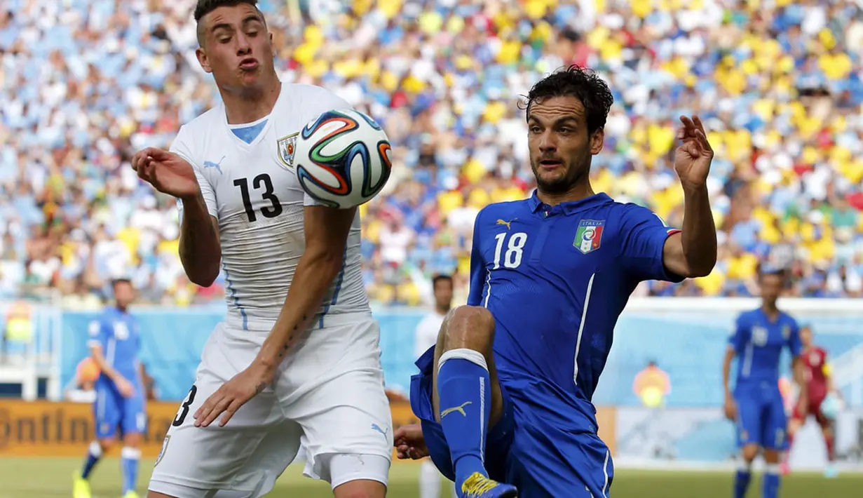 Pemain belakang Uruguay, Jose Maria Gimenez (kiri) mencoba merebut bola dari gelandang Italia, Marco Parolo, di laga penutup penyisihan Piala Dunia Grup D di Stadion das Dunas, Natal, Brasil, (24/6/2014). (REUTERS/Yves Herman)