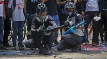 Pengunjuk rasa anti kudeta menguji senjata rakitan yang dibuat untuk berperang dengan pasukan keamanan pemerintah di Yangon, Myanmar, Rabu (17/3/2021). Demonstrasi menentang kudeta militer Myanmar terus berlangsung dan mendapat tindakan keras oleh pasukan keamanan. (AP Photo)