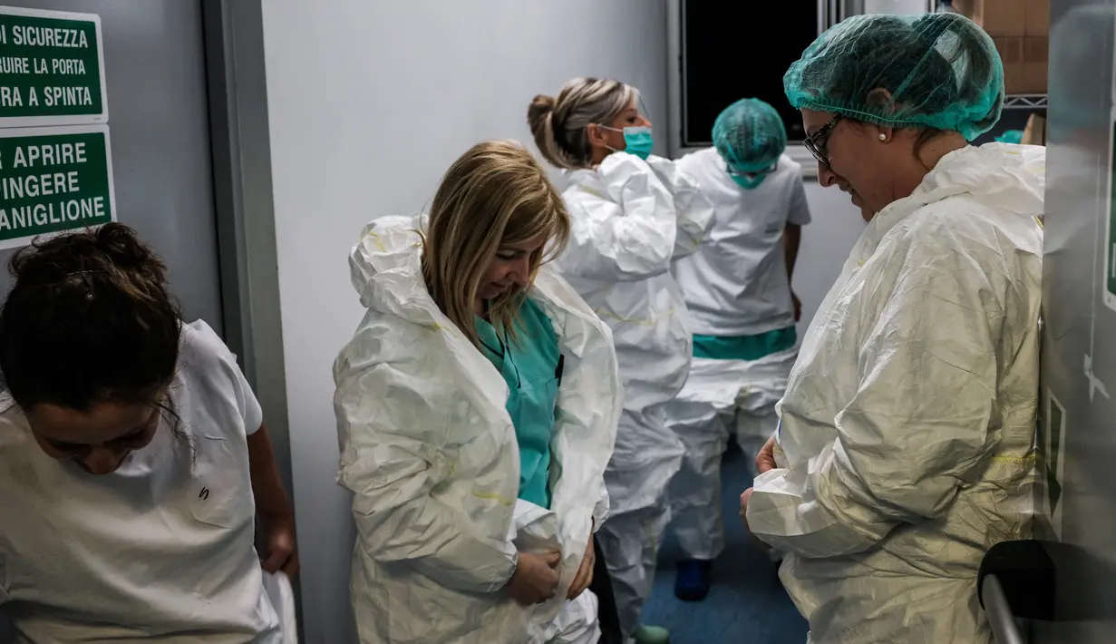 Perawat mengenakan alat pelindung diri untuk memulai shift di rumah sakit Cremona, tenggara Milan, Lombardy pada 12 Maret 2020. Jumlah kematian akibat Covid-19 di Italia sekarang yang tertinggi di dunia, menyalip China tempat wabah ini pertama kali. (Paolo MIRANDA/AFP)