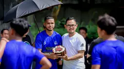 Bek Arema FC, Hasim Kipuw, mendapatkan kue ulang tahun dari Presiden Arema FC, Gilang Widya Pramana, setelah sesi latihan perdana Singo Edan, Selasa (10/5/2022). Hasim Kipuw genap berusia 34 tahun pada Senin (9/5/2022).