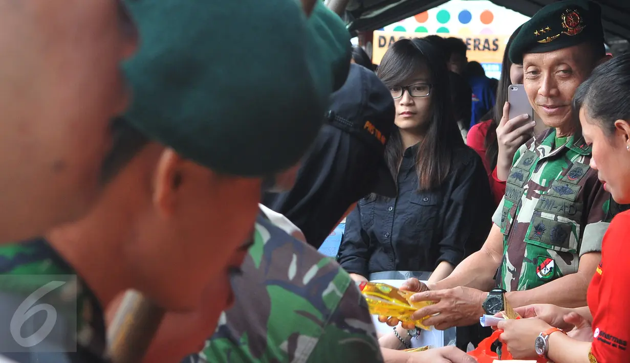 Pangkostrad Letjend TNI Mulyono (kedua kanan) melayani pembelian minyak goreng dalam bazar murah di Lapangan Kostrad, Jakarta, Selasa (7/7/2015). Bazar ini dikhususkan bagi para prajurit dan PNS di lingkungan Kostrad. (Liputan6.com/Herman Zakharia)