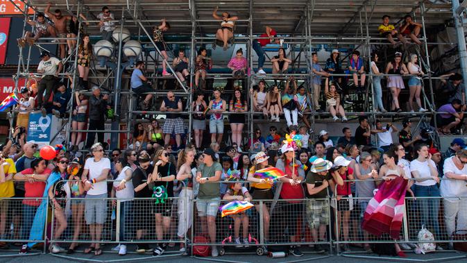 Warga menyaksikan pawai LGBT Toronto's Pride Parade di Toronto, Kanada, Minggu (23/6/2019). Pawai digelar untuk mengenang peristiwa Stonewall yang terjadi di New York pada Juni 1969. (Andrew Lahodynskyj/The Canadian Press via AP)