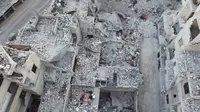 Keluarga Tareq Abu Ziad menunggu waktu berbuka puasa di tengah reruntuhan rumah mereka yang hancur setelah serangan militer pasukan pemerintah dan sekutunya di Kota Ariha, Provinsi Idlib, Suriah, Senin (4/5/2020). Muslim Suriah melewati Ramadan tahun ini masih dalam kondisi perang. (AAREF WATAD/AFP)
