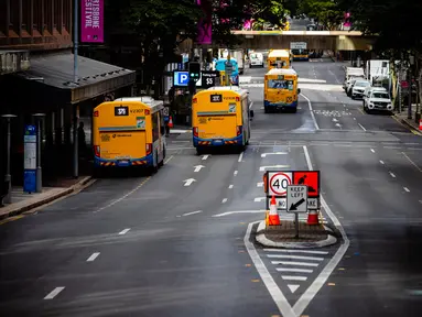 Bus berjalan di sepanjang jalan di Brisbane, Australia (30/6/2021). Kota itu menjadi sunyi karena dari penguncian dengan Australia memerangi wabah varian Delta yang sangat menular dari Covid-19. (AFP/Patrick Hamilton)