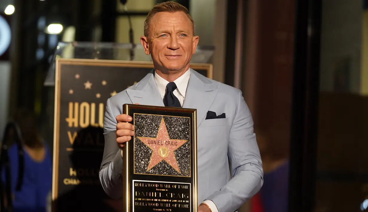 Daniel Craig berpose dengan replika bintang barunya di Hollywood Walk of Fame pada upacara penghargaan di Los Angeles, Rabu (6/10/2021). Craig menjadi bintang Bond keempat yang menerima bintang di Hollywood Walk of Fame setelah Roger Moore, David Niken, dan Pierce Brosnan. (AP Photo/Chris Pizzello)