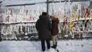 Orang-orang membaca pesan pada pita yang ditempatkan di pagar kawat berduri, berharap untuk penyatuan kembali kedua Korea, ketika m mengunjungi Paviliun Imjingak dekat perbatasan dengan Korea Utara, untuk merayakan Tahun Baru Imlek di Paju, Korea Selatan, Selasa (1/2/2022). (AP Photo/Ahn Young-joon)