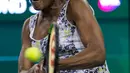 Venus Williams memukul bola saat melawan adiknya Serena Williams saat putaran ketiga turnamen tenis BNP Paribas Open Open di Indian Wells Tennis Garden, California (12/3). Venus Williams menang 6-3, 6-4.  (AP Photo/Crystal Chatham)