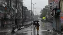 Para perempuan berjalan di sepanjang jalan yang sepi di Sadar Bazar selama jam malam akhir pekan di New Delhi, India, Sabtu (8/1/2022). Pihak berwenang memberlakukan jam malam selama akhir pekan di seluruh negara bagian Delhi saat jumlah kasus covid-19 kembali melonjak. (Prakash SINGH/AFP)