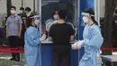 Seorang pekerja medis membawa sampel dari petugas polisi selama pengujian COVID-19 di Badan Kepolisian Metropolitan Seoul di Seoul, Korea Selatan, Rabu, (19/8/2020). (AP Photo / Ahn Young-joon)
