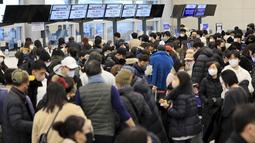 Penumpang menunggu tiket penerbangan mereka di Bandara Internasional Jeju di Pulau Jeju, Korea Selatan, Selasa, 24 Januari 2023. Ribuan pelancong memadati bandara kecil di pulau Jeju Korea Selatan untuk mendapatkan penerbangan setelah penundaan karena kendala angin kencang dan salju tebal.  (Park Ji-ho/Yonhap via AP)