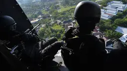 Prajurit TNI Batalyon Raider 112/Dharma Jaya melihat keluar dari helikopter ketika berpartisipasi pada latihan penanggulangan anti teror di Banda Aceh, Sabtu (11/5/2019). Latihan ini untuk meningkatkan kemampuan dalam melaksanakan tugas operasi yang bersifat khusus. (CHAIDEER MAHYUDDIN/AFP)