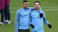 Pemain Manchester City, Gabriel Jesus merangkul Bernardo Silva saat sesi latihan jelang laga Liga Champions di Manchester, Selasa (6/3/2018). Manchester City akan berhadapan dengan FC Basel. (AFP/ Oli Scarff)