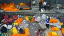 Para pedagang menjajakan bunga untuk dijual selama Festival Durga Puja di pinggir jalan Siliguri, India, Selasa (12/10/2021). Durga Puja juga disebut Durgotsab adalah festival tahunan di Asia Selatan untuk memuja dewi Durga dari agama Hindu. (DIPTENDU DUTTA/AFP)