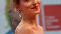 Dakota Johnson tersenyum di depan penggemarnya saat menghadiri pemutaran film "'Black Mass" di Festival Film Venesia ke-72 di Italia, (5/9/2015). Bintang film 'The Fifty Shades Of Grey' itu tampil sensual tanpa mengunakan bra. (AFP PHOTO/GIUSEPPE CACACE)