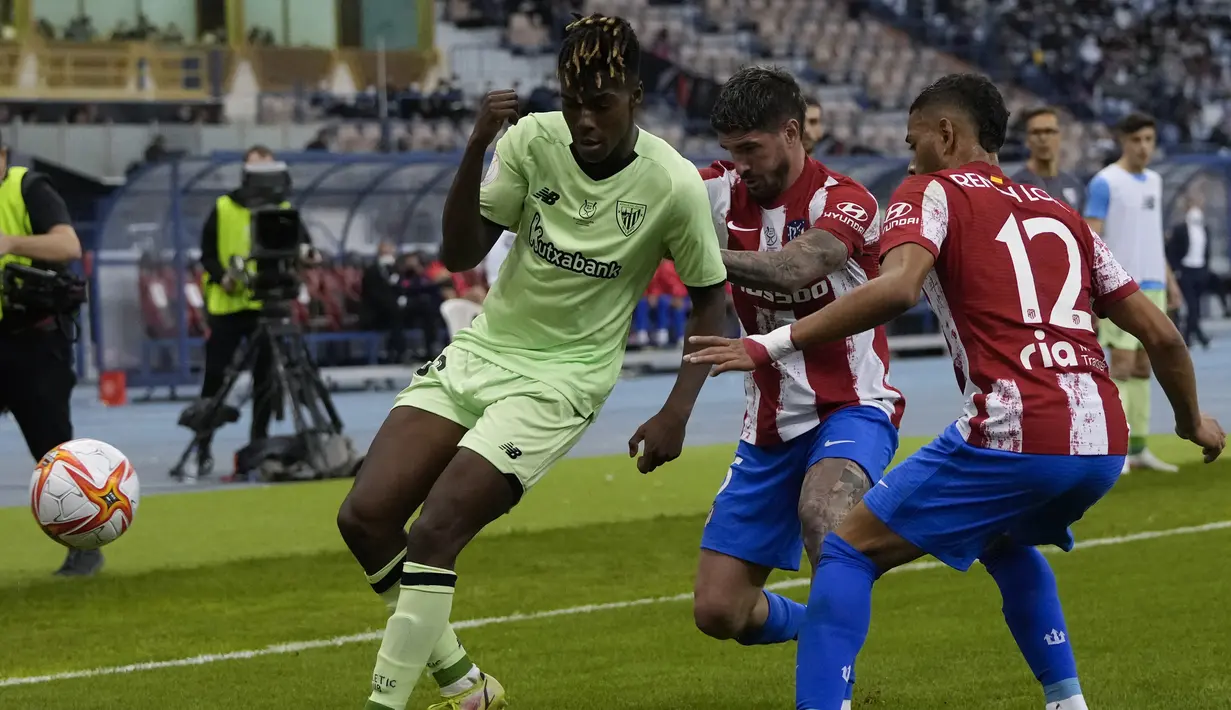 Penyerang Athletic Bilbao Nico Williams beraksi di depan pemain Atletico Madrid Rodrigo De Paul dan Renan Lodi pada semifinal Piala Super Spanyol 2022 di Stadion Raja Fahd, Jumat (14/1/2022) dinihari WIB. Athletic Bilbao membuat kejutan dengan mendepak Atletico Madrid 2-1. (AP Photo/Hassan Ammar)
