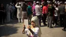 Seorang anak perempuan mengambil gambar seusai pelaksanaan salat Idul Fitri di masjid Niujie, Beijing, 26 Juni 2017. Umat muslim di berbagai penjuru dunia merayakan Idul Fitri, yang menandai berakhirnya bulan suci Ramadan. (AP Photo/Mark Schiefelbein)