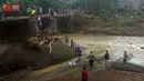 Tim SAR memperbaiki jembatan setelah tanah longsor melanda Gowa, Sulawesi Selatan, Jumat (25/1). Proses perbaikan terkendala cuaca buruk. (YUSUF WAHIL/AFP)