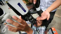 Seorang mahasiswa mencoba peralatan teleskop yang akan di gunakan untuk mengamati gerhana matahari di taman Pintar Yogyakarta, (2/3). Kawasan Tugu menjadi salah satu tempat pengamatan gerhana matahari pada 9 Maret 2016. (Liputan6.com/Boy Harjanto)