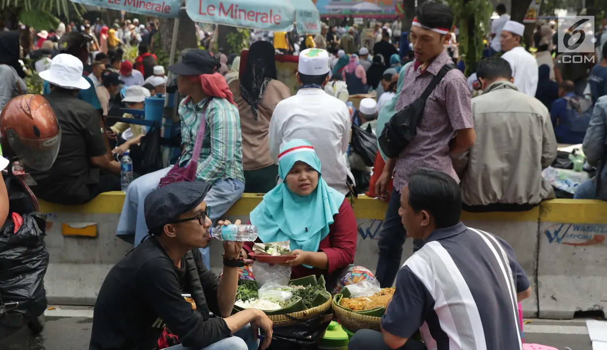 Pedagang asongan melayani pembeli yang mayoritas massa yang melakukan aksi di sekitaran Jalan Medan Merdeka Barat, Jakarta, Kamis (27/6/2019). Massa yang melakukan aksi terkait sidang putusan perselisihan hasil Pilpres 2019 memberi keuntungan bagi para pedagang. (Liputan6.com/Helmi Fithriansyah)