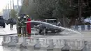 Petugas pemadam kebakaran setempat menyemprotkan air untuk membersihkan sisa ledakan bom bunuh diri di Kabul, Afghanistan (15/11). (AP Photo/Rahmat Gul)