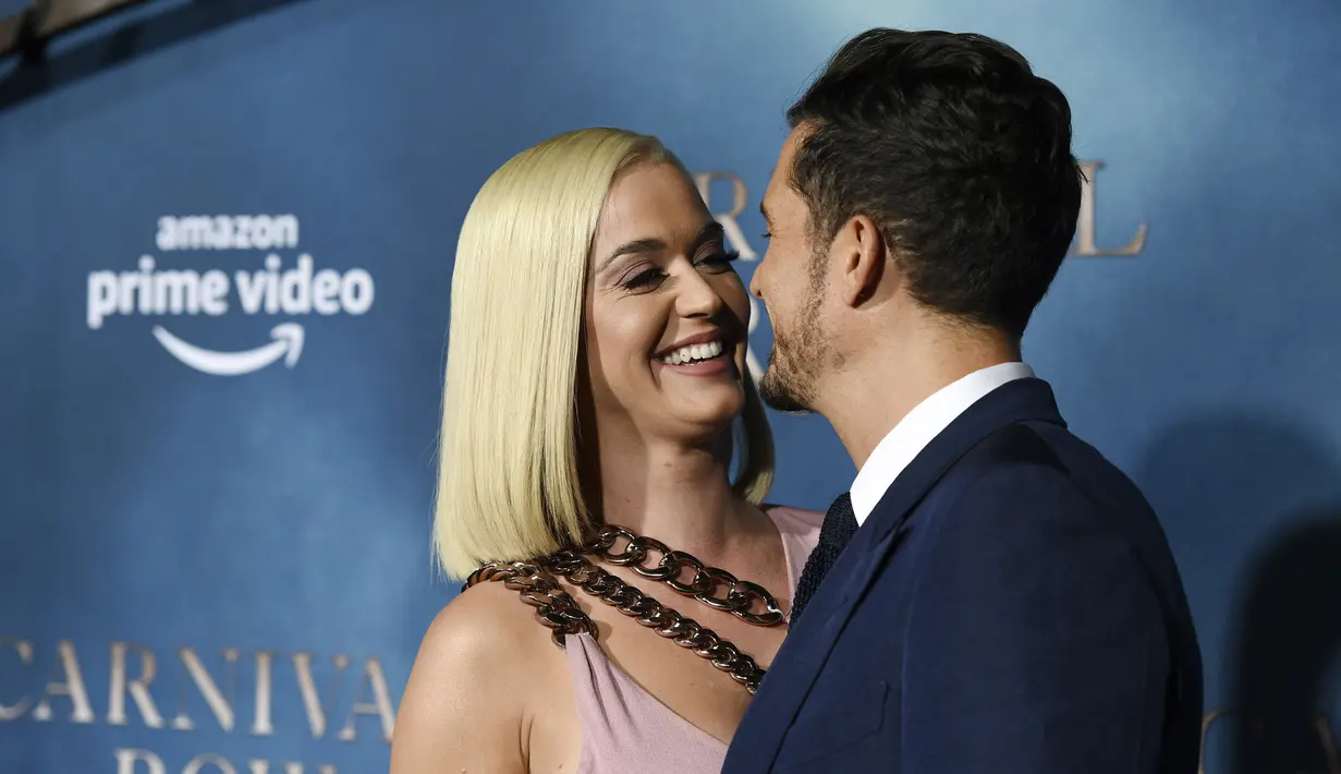 Penyanyi Katy Perry tertawa dengan pacarnya Orlando Bloom saat menghadiri pemutaran perdana untuk serial televisi "Carnival Row" di Los Angeles, California, AS (21/8/2019). Katy Perry dan Orlando Bloom tampil mesra dengan saling mencium di acara tersebut. (AP Photo/Chris Pizzello)