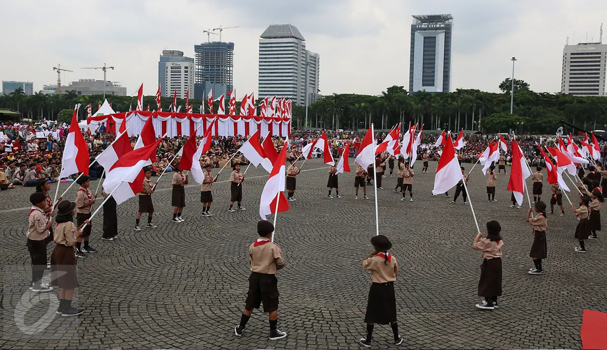 Sejumlah siswa membawa bendera merah putih saat acara Nusantara Bersatu di Monas, Jakarta, Rabu (30/11). Sekitar 40.000 orang hadir dalam acara tersebut, dengan mengenakan pita merah putih yang diikatkan di kepala. (Liputan6.com/Johan Tallo)