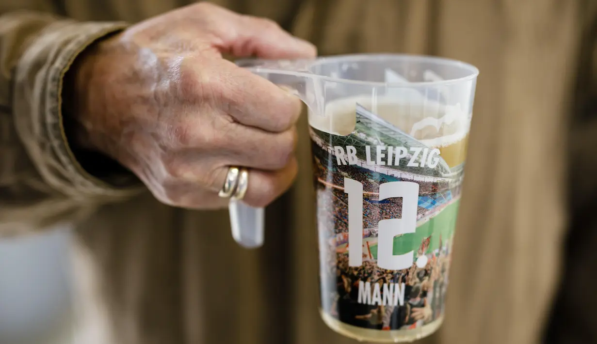 A man holding a beer cup is seen prior to the Bundesliga match between RB Leipzig and VfL Wolfsburg at Red Bull Arena on October 19, 2019 in Leipzig, Germany. (Photo by Reinaldo Coddou H./Bundesliga/Bundesliga Collection via Getty Images)