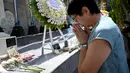 Seorang wanita asal Jepang berdoa di Monumen Bom Bali, Kuta, dekat Denpasar pada Sabtu (12/10/2019). MeMperingati 18 tahun peristiwa bom Bali yang terjadi pada 12 Oktober 2002, wisatawan dan kerabat korban mengunjungi tugu peringatan untuk berdoa dan tabur bunga. (SONNY TUMBELAKA / AFP)