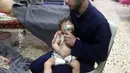 Petugas medis memberikan oksigen kepada bayi setelah diduga terkena serangan senjata kimia di Kota Douma, dekat Damaskus, Suriah, Minggu (8/4). PBB menyatakan pemerintah Suriah harus bertanggung jawab. (Syrian Civil Defense White Helmets via AP)