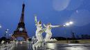 Dua orang atlet Mesir melompat di depan menara Eiffel saat acara pembukaan Olimpiade 2024 di Paris, Sabtu (27/7/2024).  (AP Photo/Andy Wong)