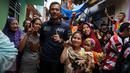 Calon Gubernur DKI Jakarta Agus Harimurti Yudhoyono (AHY) berfoto bersama warga saat blusukan di kawasan Kampung Pulo, Jakarta, Selasa (27/12). AHY datang ke tempat tersebut untuk mendengarkan keluhan warga. Liputan6.com/Gempur M Surya)
