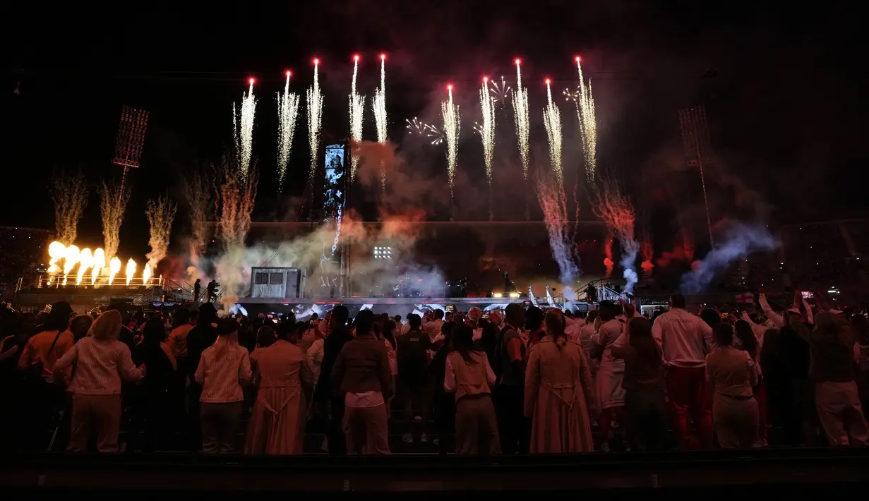 Orang-orang menyaksikan kembang api menerangi langit saat upacara penutupan Commonwealth Games di stadion Alexander di Birmingham, Inggris, Senin (8/8/2022). Commonwealth Games 2022 berakhir pada hari Senin setelah upacara penutupan yang berkilauan di Alexander Stadium di Birmingham. (AP Photo/Alastair Grant)