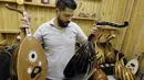 Seorang pengrajin, Ali Khalifeh memeriksa alat musik Oud setelah selesai di buat di sebuah rumah produksi di Damaskus, Suriah (17/7). Biasanya Oud ini dimainkan sambil diiringi gendang. (AFP Photo/Louai Beshara)