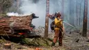 <p>Seorang petugas pemadam kebakaran berusaha untuk menahan api Cedar Creek di sebelah timur Oakridge, Oregon, Senin (12/9/2022). Petugas pemadam kebakaran mengatakan dalam beberapa hari ini terjadi pertumbuhan api yang ekstrem di timur dan barat. (Photo by Dan Morrison/AFP)</p>
