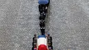 Anggota kepolisian Prancis menggotong peti mati Letnan Kolonel Arnaud Beltrame dalam upacara pemakaman nasional di Hotel des Invalides, Paris, Rabu (28/3). Meski berlangsung khidmat, namun hujan deras sempat mengguyur sepanjang upacara (AP/Christophe Ena)