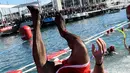 Peserta berkostum Sinterklas melompat ke dalam air pada kompetisi renang 'Copa Nadal' di Port Vell, Barcelona, Rabu (25/12/2019). Lebih dari 300 peserta menempuh jarak sejauh 200 meter pada tradisi lama yang digelar  saat hari Natal tersebut. (Josep LAGO / AFP)