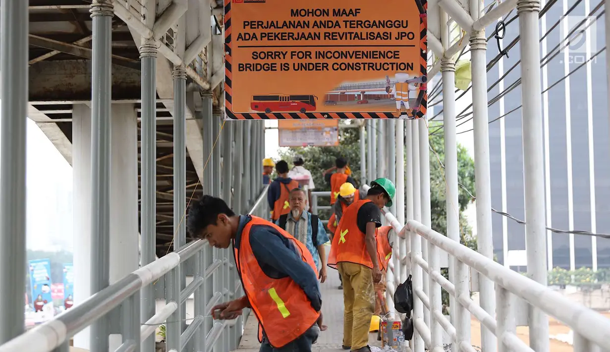 Pekerja mengecat jembatan penyeberangan orang di kawasan Senayan, Jakarta, Jumat (6/7). Pengecatan tersebut merupakan bagian dari proyek revitalisasi JPO guna meningkatnya kenyamanan pejalan kaki. (Liputan6.com/Immanuel Antonius)
