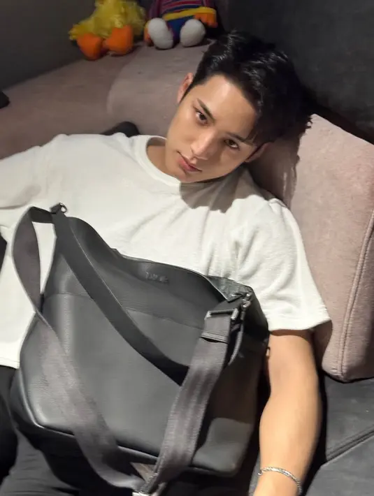 <p>Mingyu dari Seventeen mengenakan tas Dior koleksi Vertical Hobo Bag. Ia memadukannya dengan kaos putih dipadukan celana hitam. [Dior]</p>