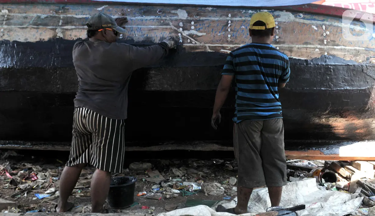 Pekerja menyelesaikan proses perbaikan kapal nelayan di pesisir Marunda, Jakarta, Selasa (22/10/2019). Jasa perbaikan kapal nelayan merupakan salah satu mata pencaharian utama warga pesisir Marunda selain mencari ikan di laut. (merdeka.com/Iqbal Nugroho)