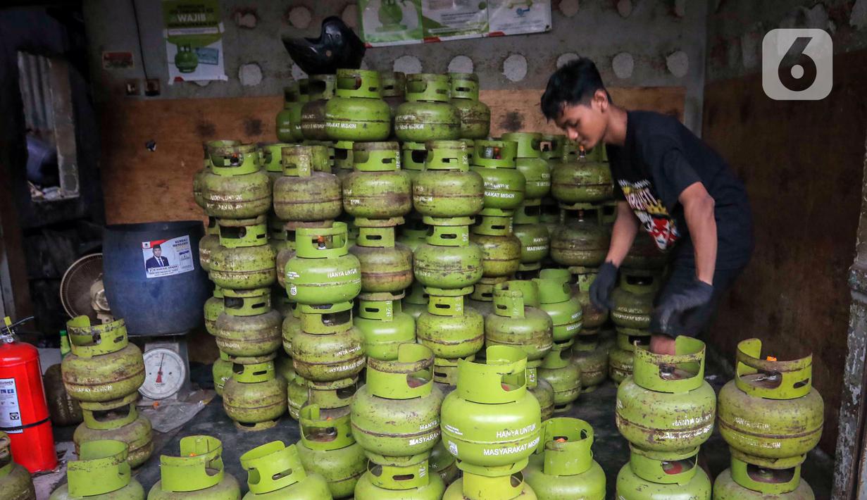 Pekerja menata tabung liquefied petroleum gas (LPG) 3 Kg di sebuah agen di kawasan Jakarta, Rabu (27/12/2023). Pemerintah mendorong penyaluran LPG 3 Kg lebih tepat sasaran dengan menggunakan Kartu Tanda Penduduk (KTP) mulai 1 Januari 2024. (Liputan6.com/Angga Yuniar)