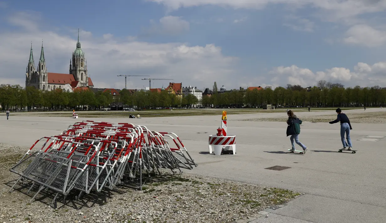 Orang-orang bermain skateboard di area Theresienwiese, tempat festival bir 'Oktoberfest' diadakan, di depan gereja St. Pauls, di Munich, Senin (3/5/2021). Jerman kembali membatalkan festival bir Oktoberfest untuk tahun kedua karena pandemi covid-19. (AP Photo/Matthias Schrader)