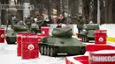 Anak-anak ditemani seorang pria mengendarai model tank T-34 era Soviet yang legendaris di objek wisata petualangan anak-anak Tankodrom di taman Sokolniki di Moskow, Rusia (6/1/2020). Anak-anak dapat berlomba dengan menggunakan tank ini di sekitar kursus slalom. (AP Photo/Alexander Zemlianichenko)