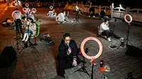 Para live streamer berkumpul di jembatan Guilin untuk melakukan siaran langsung luar ruangan. (AFP/Jade Gao)