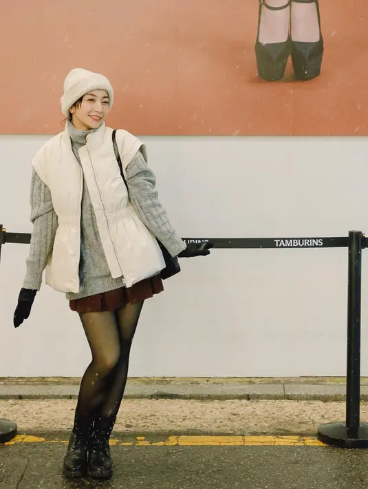 Cantik bak remaja Hesti tampil dengan turtleneck abu-abu yang oversized, dipadu puffer vest berwarna putih yang serasi dengan beanienya. Penampilannya semakin manis dengan mini pleated skirt berwarna wine dan midi boots hitam. [Foto: Instagram/hestipurwadinata]