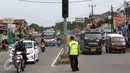 Petugas polisi berjaga di pertigaan Jatinangor, Sumedang, Jawa Barat, Sabtu (2/7). Mengatasi kepadatan kendaraan pemudik, petugas melakukan sistem pengalihan arus dengan menutup jalur dari arah Sumedang menuju Bandung Kota (Liputan6.com/Immanuel Antonius)