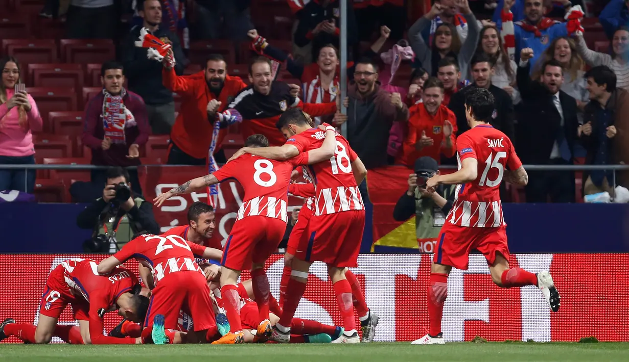 Pemain Atletico Madrid merayakan gol yang berhasil dicetak oleh Antoine Griezmann saat melawan Real Madrid dalam pertandingan La Liga Spanyol di stadion Santiago Bernabeu di Madrid (8/4). (AP Photo / Francisco Seco)