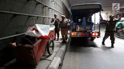 Petugas Satpol PP dari Kecamatan Setia Budi merazia tunawisma yang sedang sedang tidur di dalam gerobaknya di Kawasan Kuningan, Jakarta, Rabu (15/11). (Liputan6.com/JohanTallo)