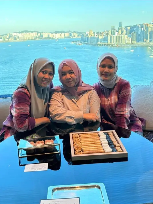 Selain menikmati taman hiburan, ketiga pengasuh ini juga sempat bersantai di sebuah tempat dengan pemandangan kota Hong Kong yang indah. Hidangan ringan seperti camilan manis tersaji di meja mereka, melengkapi suasana akrab dan penuh canda tawa. (Liputan6.com/IG/@ciamyayu_94)