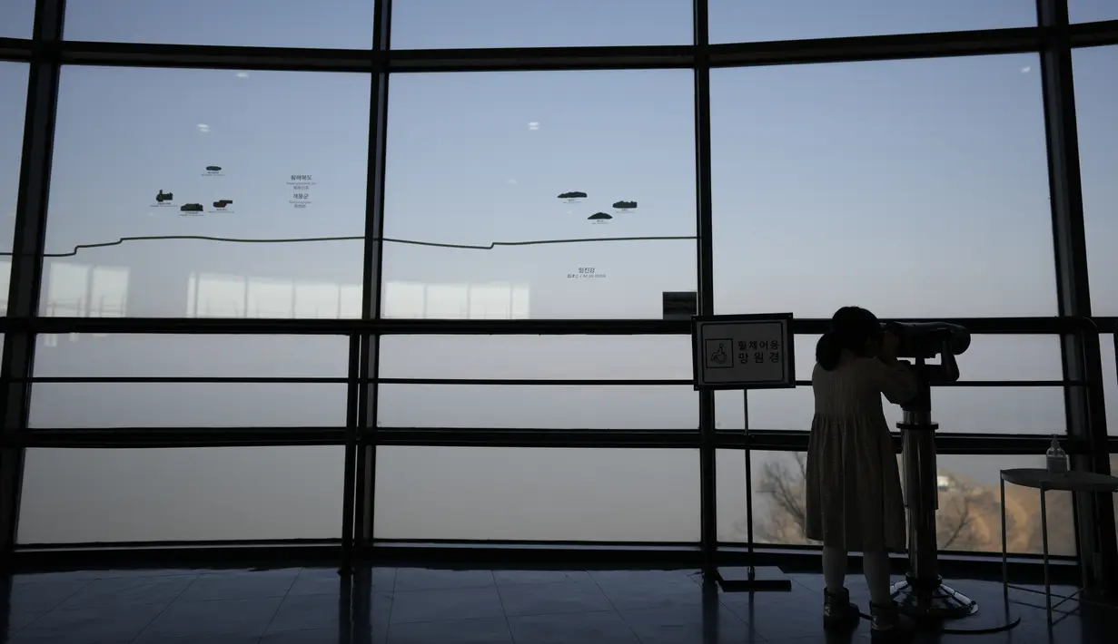 Seorang pengunjung menggunakan teropong untuk melihat sisi Korea Utara dari observatorium penyatuan di Paju, Korea Selatan, Jumat (24/2/2023). Korea Utara (Korut) kembali melakukan uji coba rudal.  (AP Photo/Lee Jin-man)