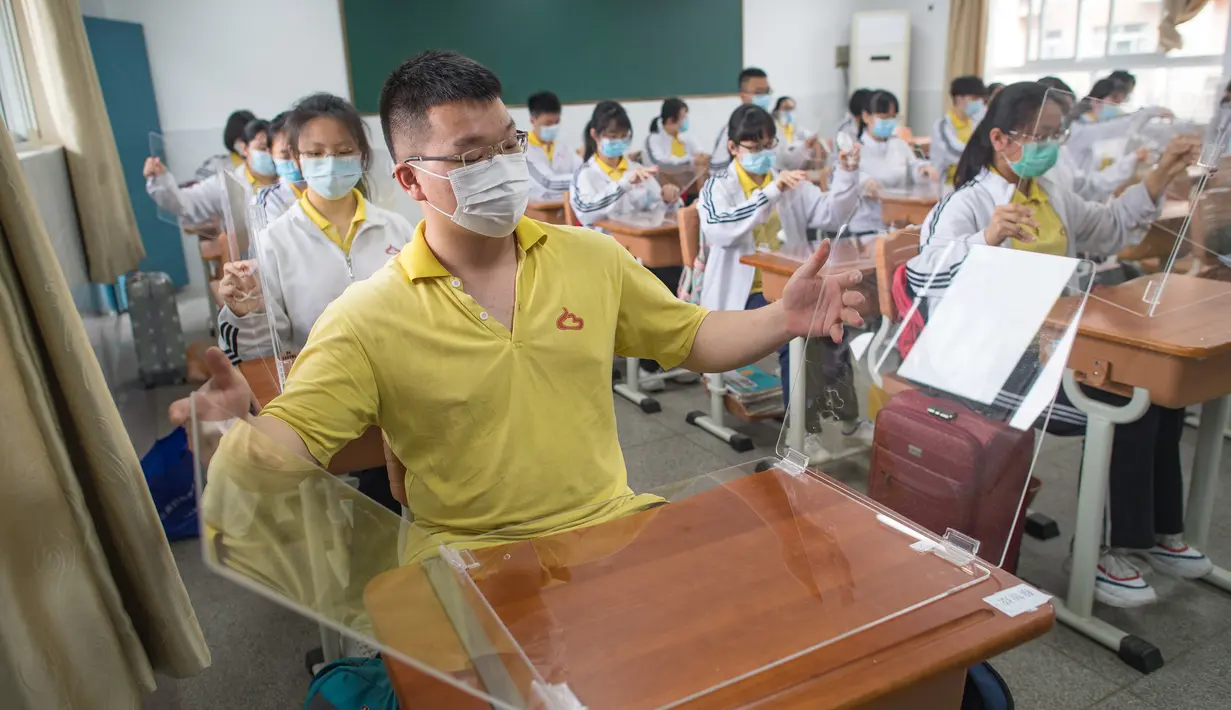 Siswa belajar dengan pemisah pada masing-masing meja mereka sebagai langkah pencegahan penyebaran COVID-19 di Sekolah Menengah No. 23 Wuhan, Wuhan, Provinsi Hubei, China, Rabu (6/5/2020). Sekitar 57.800 siswa tingkat akhir dari 121 SMA dan kejuruan di Wuhan kembali bersekolah. (Xinhua/Xiao Yijiu)